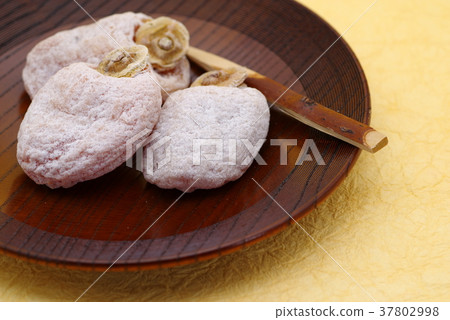 Ichida年糕在一個木糖果板材服務的干米糕黃色日文報紙背景c上面左特寫鏡頭 Ichida年糕在一個木糖果板材服務的干米糕黃色日文報紙背景c上面左特寫鏡頭 37802998