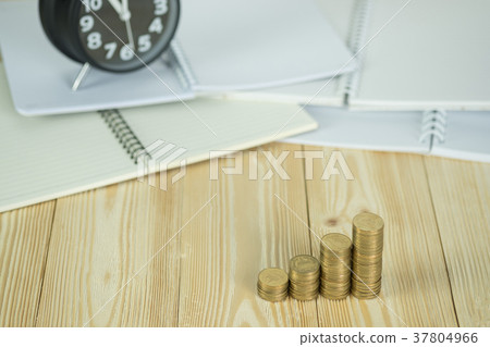 Coins stack with vintage alarm clock and notebook 37804966