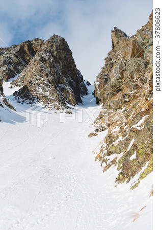 Close-up. View of a snowy couloir between sharp Close-up. View of a snowy couloir between sharp 37806623