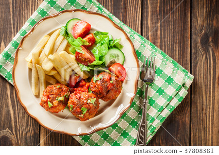 Roasted meatballs in tomato sauce with fries Roasted meatballs in tomato sauce with fries 37808381