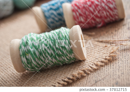 sewing thread spool bobbin on wooden table 37812715