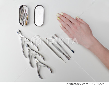 Set of tools for manicure and a female hand Set of tools for manicure and a female hand 37812749