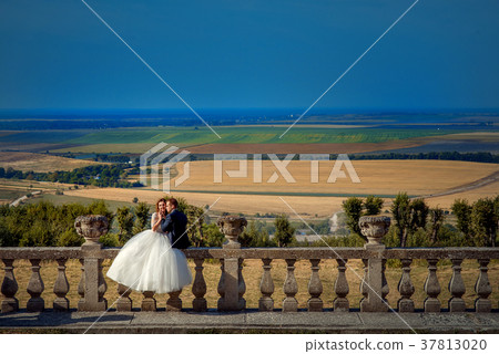 Romantic portrait of the newlywed couple sitting 37813020