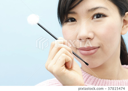 A young woman cleaning her ears 37815474