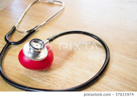 Red heart and a stethoscope on wooden table 37815974