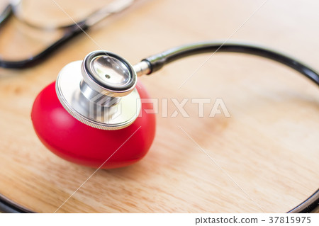 Red heart and a stethoscope on wooden table 37815975