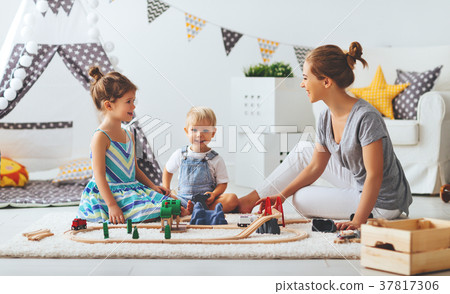 family mother and children play a toy railway in   playroom. 37817306