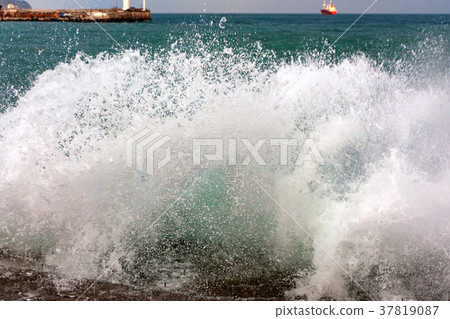 Waves crushing into the rocks 37819087
