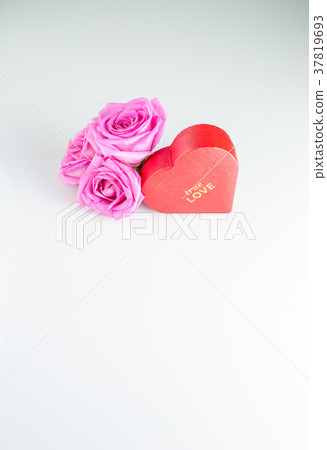Red heart-shaped box and rose flowers . 37819693