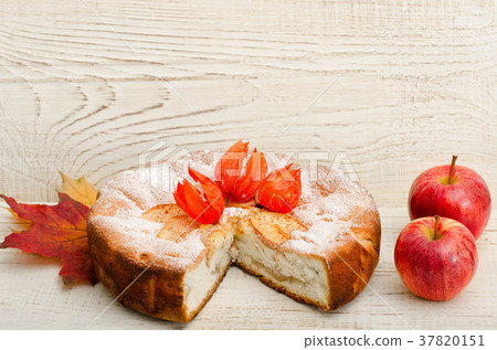 Cut apple tart and ripe apples on wooden planks Cut apple tart and ripe apples on wooden planks 37820151