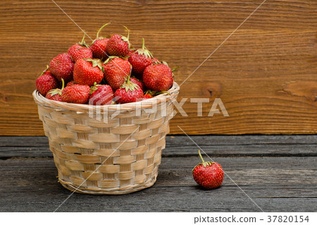 Basket of ripe strawberries on black wooden table Basket of ripe strawberries on black wooden table 37820154