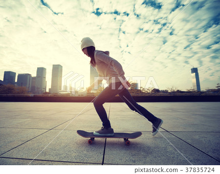 female skateboarder riding with skateboard on city 37835724