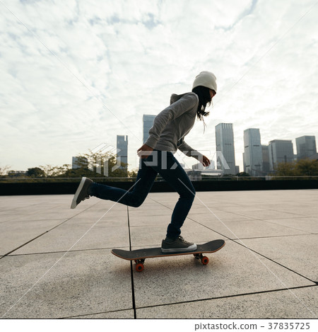 female skateboarder riding with skateboard on city 37835725