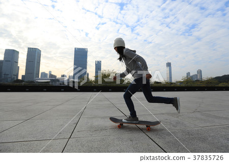female skateboarder riding with skateboard on city 37835726