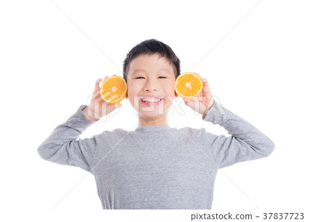 Young boy holding orange and smiles over white  37837723