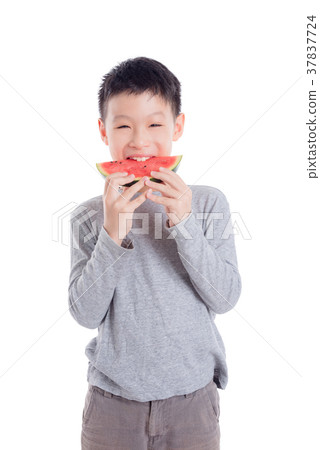 Young boy eating a slice of watermelon over white  37837724