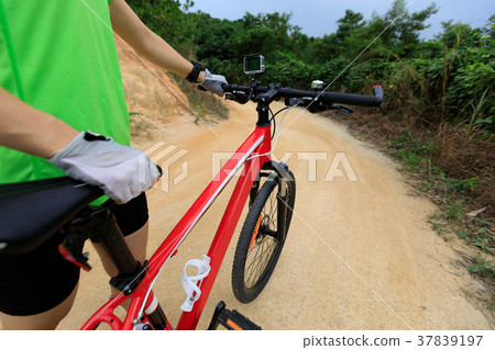cyclist riding mountain bike on country road 37839197