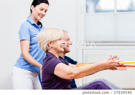 Senior couple in physiotherapy doing exercise with Senior couple in physiotherapy doing exercise with 37839540