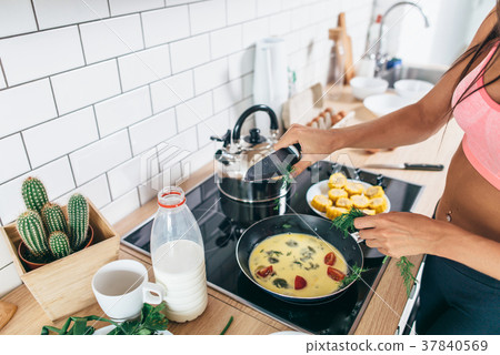 Fit woman preparing healthy breakfast in kitchen 37840569
