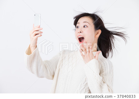 Surprised middle woman (smartphone) 37840833
