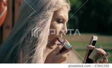 Close-up of a beautiful woman doing makeup 37841395