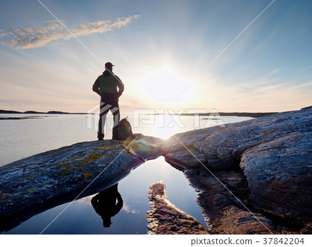 Young standing man with backpack. Hiker on stone 37842204