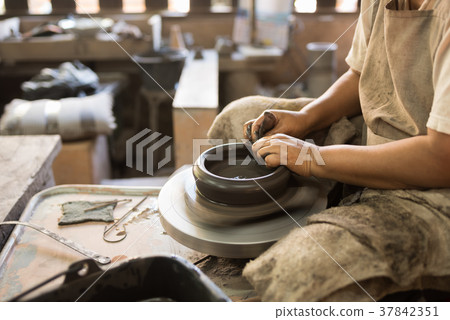 potter shaping soft clay to make an earthen pot potter shaping soft clay to make an earthen pot 37842351