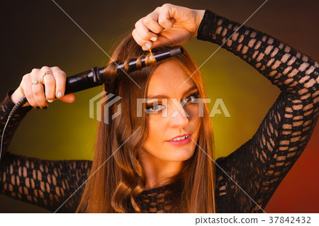 Happy woman curling her long brown hair 37842432