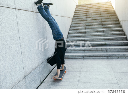 skateboarder doing a handstand on skateboard  37842558