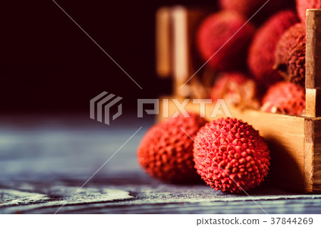 Lychee fruit in wooden box close Lychee fruit in wooden box close 37844269