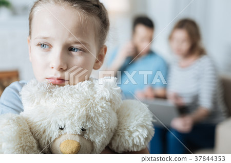 Unhappy little girl hugging her teddy bear Unhappy little girl hugging her teddy bear 37844353