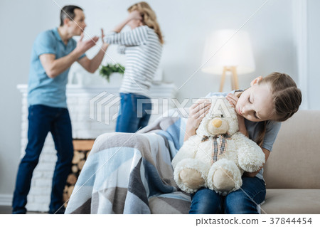 Unhappy girl holding a teddy bear 37844454