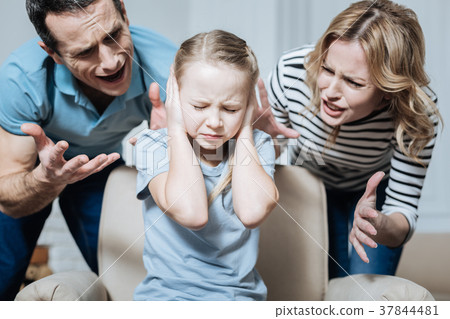 Unsmiling girl and her parents shouting at her 37844481