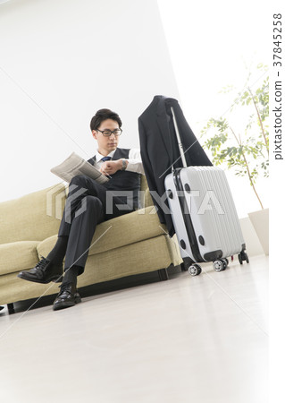 Businessman reading a newspaper on the couch Businessman reading a newspaper on the couch 37845258