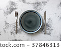 Plate on white wooden background with utensils 37846313