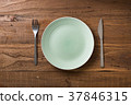 Green Plate on brown wooden background  37846315