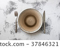 Plate on white wooden background with utensils 37846321