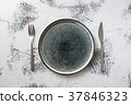Plate on white wooden background with utensils 37846323