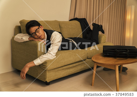 Businessman sleeping on the sofa tired of work Businessman sleeping on the sofa tired of work 37849583