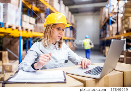 Young warehouse workers with laptop working. Young warehouse workers with laptop working. 37849929