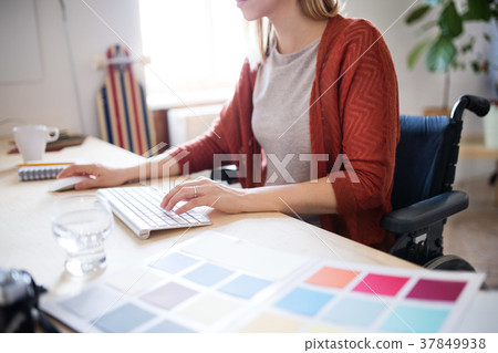 Businesswoman in wheelchair at the desk in her 37849938
