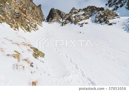 Close-up. View of a snowy couloir between sharp 37851058