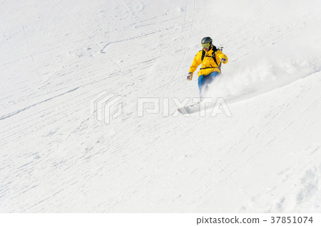 A man a snowboarder freerider descends a 37851074
