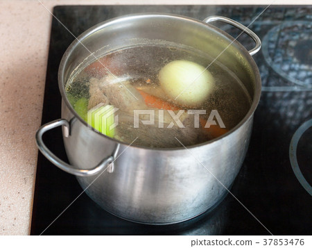 simmering meat broth in stockpot on ceramic cooker 37853476