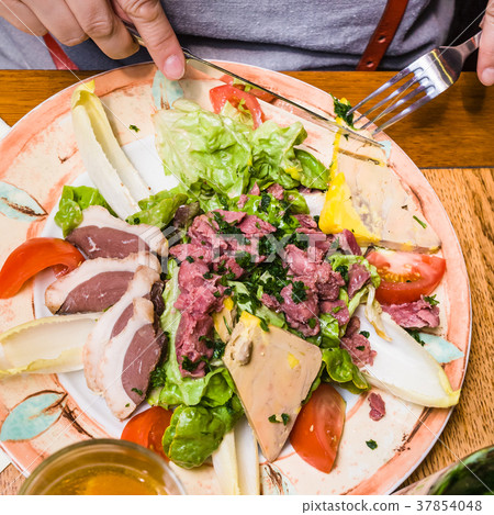 woman eats typical local Norman meat appetizers 37854048
