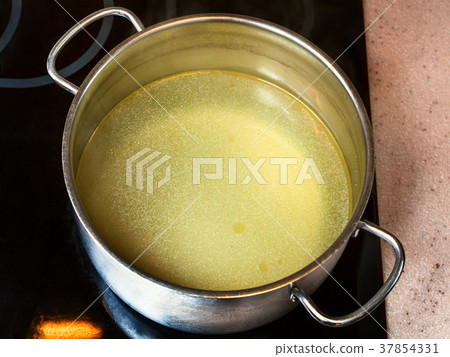clear fat beef bouillon in steel stockpot clear fat beef bouillon in steel stockpot 37854331