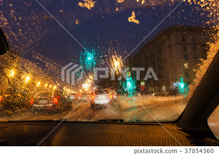 melting snow on car windshield in evening 37854360