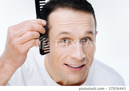 Portrait of a nice positive man using a comb Portrait of a nice positive man using a comb 37856441