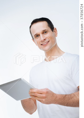 Delighted happy man using a digital device Delighted happy man using a digital device 37856724