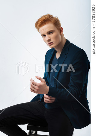 Unsmiling young man touching his wrist 37858929